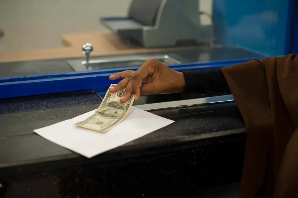 Customer handing cash across a bank counter